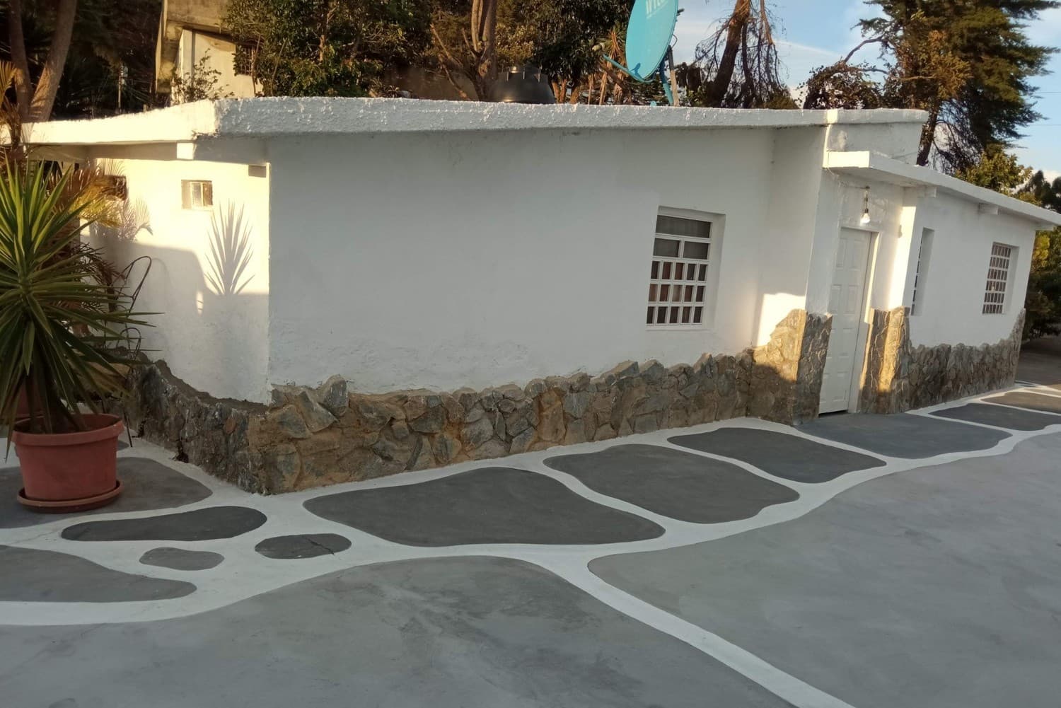 Fachada blanca de la villa con piso esculpido a mano