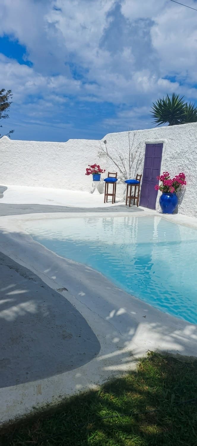 Piscina con cascada y montañas de fondo